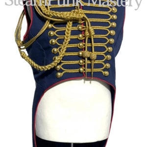 May include: A navy blue and red military-style vest with gold braid trim and buttons. The vest has a long tail and is decorated with gold braid and buttons.