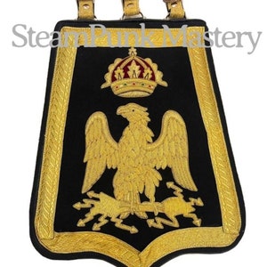 Könnte beinhalten: Ein schwarzes Samtbanner mit goldener Stickerei, das einen gekrönten Adler mit Blitzen darstellt. Das Banner hat drei Lederriemen oben und der Text "SteamPunk Mastery" ist oben sichtbar.