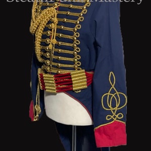 May include: A blue and red military-style jacket with gold trim and buttons. The jacket has a long tail and features a gold braid design on the sleeves. "SteamPunk Mastery" is written in white text on a black background.