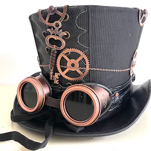 Pu&ograve; includere: Cappello a cilindro steampunk nero con occhiali color rame e ingranaggi decorativi. Il cappello presenta un design a gessato ed &egrave; adornato da una chiave e una catena. Gli occhiali hanno lenti scure e un cinturino in pelle.