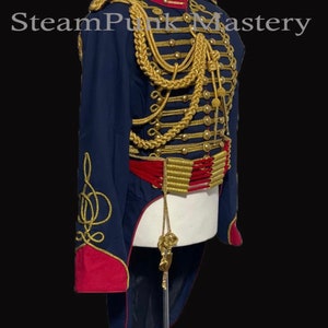 May include: A blue and red military-style jacket with gold trim and a long tail. The jacket has a high collar and a row of buttons down the front. The jacket is decorated with gold braid and tassels.