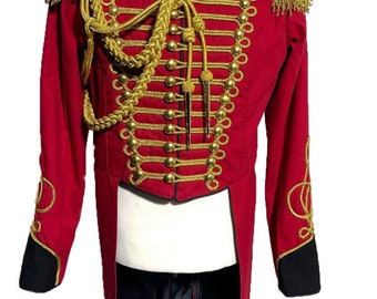 Könnte beinhalten: Eine rote Militärjacke mit goldenen Verzierungen und Knöpfen. Die Jacke hat einen langen Schwanz und ist mit einer geflochtenen Schnur und Quasten verziert.