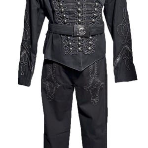 May include: Black steampunk-style outfit with intricate silver embellishments. The ensemble includes a jacket with rows of silver buttons, decorative embroidery, and a matching belt. The pants also feature embroidered details. The text "STEAMPUNK MASTERY" is visible.