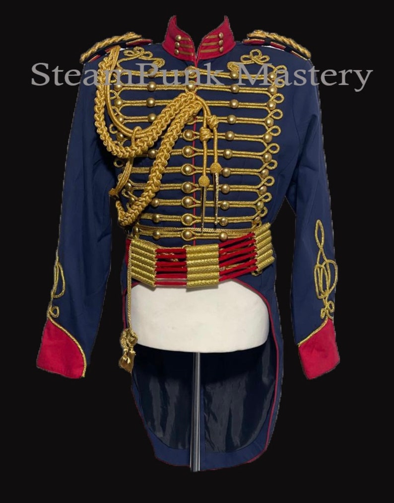 May include: A navy blue jacket with gold and red trim. The jacket has a high collar and a long tail. It features a gold braid design and gold buttons. The jacket is on a mannequin.