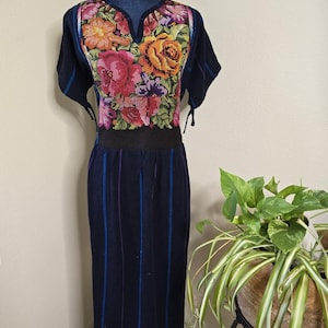 May include: A black and blue striped dress with a floral embroidered neckline. The embroidery features pink, yellow, orange, and green flowers.