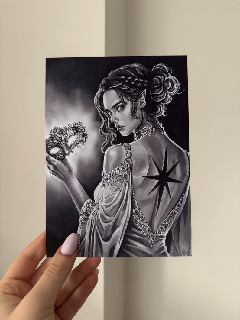 May include: Black and white illustration of a woman with pointed ears, wearing a gown and holding a mask. A star-shaped tattoo is visible on her back. The artwork has a fantasy theme.