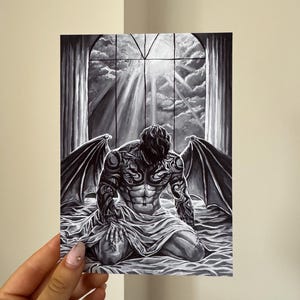 Pode incluir: Obra de arte a preto e branco que retrata uma figura ajoelhada com grandes asas e tatuagens intrincadas. A figura está envolta em tecido, contra um fundo de janela com um céu nublado e raios de luz.