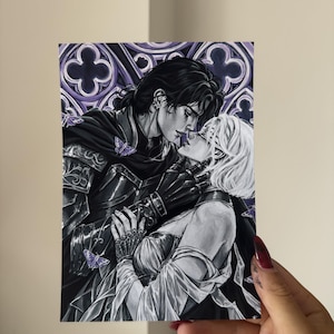 May include: A rectangular art print featuring a black and white illustration of two figures in an intimate embrace. One figure wears dark armor and a cape, while the other has short white hair. Purple butterflies and a gothic arch background.