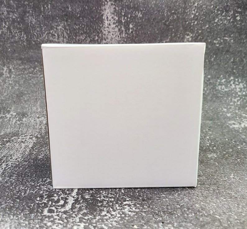 May include: A plain white cardboard box with a smooth surface.