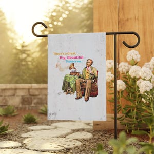 Puede incluir: Una bandera de jardín con fondo blanco y una ilustración de dibujos animados de un hombre sentado en una silla escuchando un tocadiscos. El texto en la bandera dice "There's a Great, Big, Beautiful Tomorrow..."
