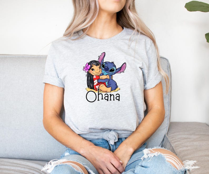 May include: A gray t-shirt with a cartoon image of Stitch hugging Lilo. The shirt has the word "Ohana" printed below the image.