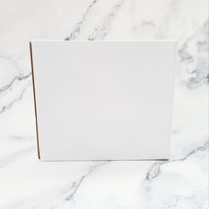 May include: A white cardboard box with a brown edge.