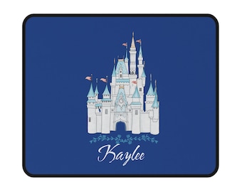 May include: A blue mousepad featuring a white castle illustration with blue turrets and pink flags. The name "Kaylee" is written in cursive below the castle, with floral accents. The mousepad has a black border.