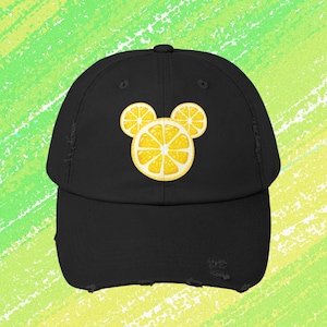 May include: Black baseball cap with a yellow lemon Mickey Mouse design.