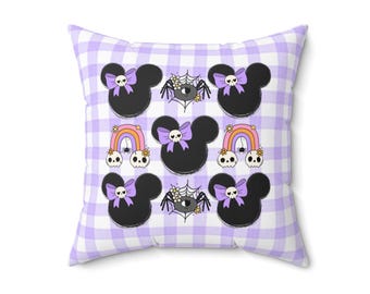 May include: Square pillow with a purple and white gingham pattern. The pillow features a repeating pattern of black mouse silhouettes with purple bows and skull accents, along with rainbows and spiderweb designs. The pillow is a decorative item.