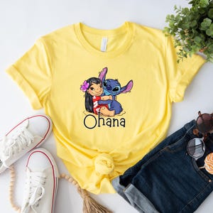 May include: Yellow t-shirt with a graphic of Stitch and Lilo hugging. The text "Ohana" is printed below the image.