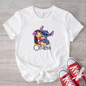 May include: White t-shirt with a graphic of Stitch and Lilo hugging. The text "Ohana" is printed below the image.