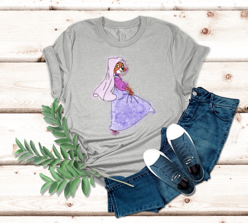 Op de afbeelding: Een heidekleurig t-shirt met een aquarel-illustratie van een cartoonvos die een paarse jurk en een roze sluier draagt.