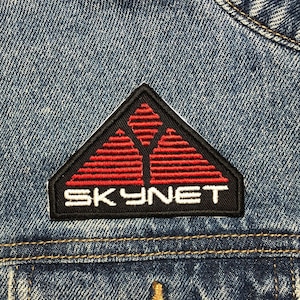 May include: A blue denim jacket with a red and black embroidered patch that says "SKYNET".