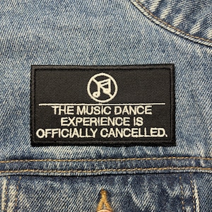 May include: Black and white iron-on patch with a musical note symbol and the text "The Music Dance Experience is Officially Cancelled."