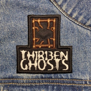 May include: A black and white embroidered patch with the text "THIRTEEN GHOSTS" and a brown and gold geometric design.