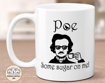Puede incluir: Taza de cerámica blanca con una ilustración negra de Edgar Allan Poe con gafas de sol y una taza. La taza tiene el texto "Poe" encima de la imagen y "Some sugar on me!" debajo.