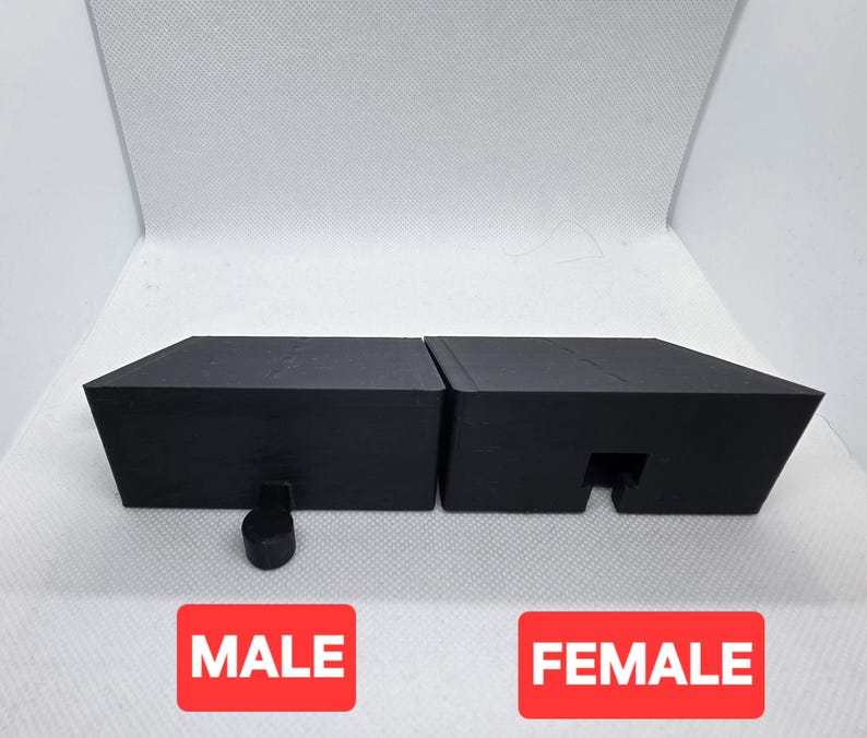 Pode incluir: Dois objetos pretos de formato geom&eacute;trico, um com uma pe&ccedil;a saliente e o outro com um recorte correspondente. A palavra "MALE" est&aacute; num ret&acirc;ngulo vermelho abaixo do primeiro objeto, e "FEMALE" abaixo do segundo.