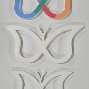 May include: Three butterfly-shaped wall decorations. The top butterfly is painted with a rainbow of colors, including purple, blue, green, red, orange, and yellow. The other two butterflies are white with shadows.