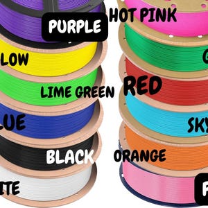 Pode incluir: Uma pilha de bobinas de filamento de impressora 3D coloridas. As cores incluem roxo, amarelo, verde lim&atilde;o, azul, preto, branco, rosa choque, verde, vermelho, azul celeste, laranja e rosa. Cada bobina &eacute; rotulada com o nome da cor.