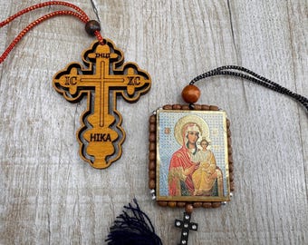 May include: Two religious pendants. One is a wooden cross with the text "IC XC" and "HIKA". The other is a rectangular pendant with an image of the Virgin Mary and child, surrounded by wooden beads. Both have cords for hanging.