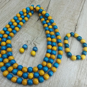 May include: A set of wooden bead jewelry featuring a long necklace and a bracelet. The necklace and bracelet are made of blue and yellow wooden beads.