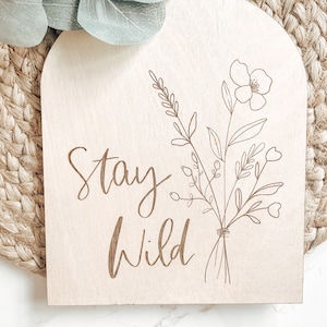 a wooden sign that says stay wild on it