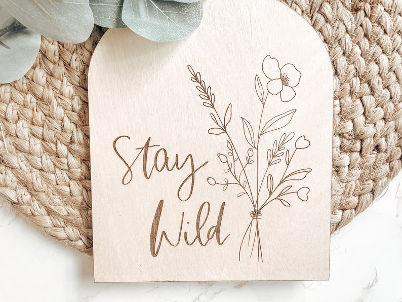 a wooden sign that says stay wild on it