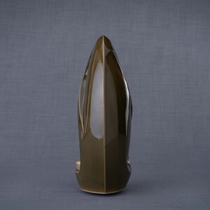Adult size urn for ashes Eternity. The urn represents a straight ellipse with a hint of the infinity symbol all along its length. There is a place for a candle in the bottom half of the urn. This ceramic art urn comes in a various colors. By Pulvis