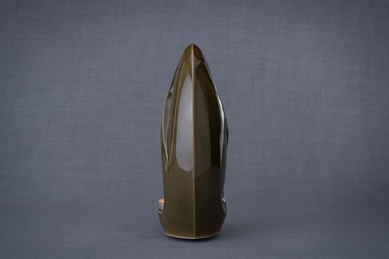 Adult size urn for ashes Eternity. The urn represents a straight ellipse with a hint of the infinity symbol all along its length. There is a place for a candle in the bottom half of the urn. This ceramic art urn comes in a various colors. By Pulvis