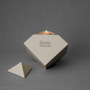 Ceramic art urn for ashes Abstract. The urn represents a cube sitting on one of its angles. The top angle pyramid is removable and there is a small place for a candle. This is a photo of all the available colors. Cube Urn for Ashes. Cube Urn