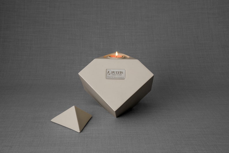 Ceramic art urn for ashes Abstract. The urn represents a cube sitting on one of its angles. The top angle pyramid is removable and there is a small place for a candle. This is a photo of all the available colors. Cube Urn for Ashes. Cube Urn
