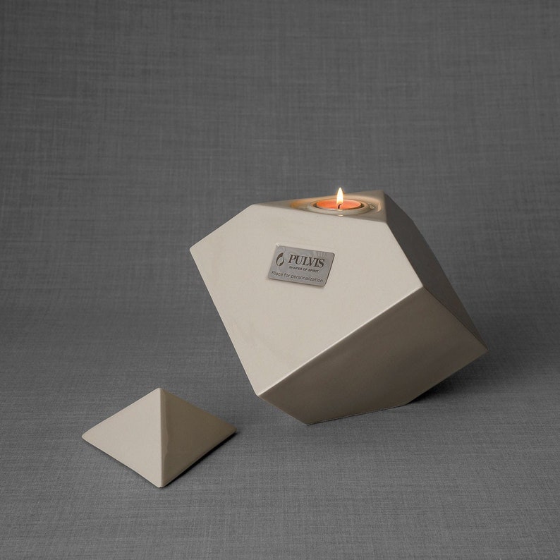 Ceramic art urn for ashes Abstract. The urn represents a cube sitting on one of its angles. The top angle pyramid is removable and there is a small place for a candle. This is a photo of all the available colors. Cube Urn for Ashes. Cube Urn