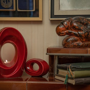 The Passage is a unique art urn for ashes. It represents a spiral with a hole in the middle. The ashes go inside the walls and there is a candle that when lit reflects on the inner side of the urn. This is a photo of a large urn and keepsake.