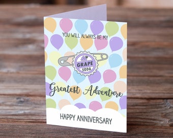May include: A light blue card with a light purple border and a light blue background. The card has a graphic of a grape soda bottle cap with a safety pin attached to it. The card has the text "You will always be my greatest adventure" and "Happy Anniversary". The background is filled with colorful balloons.