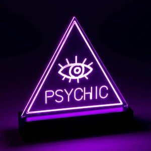 May include: A purple neon sign shaped like a triangle with an eye and the word "PSYCHIC" inside.