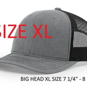 May include: A gray and black XL trucker hat with a curved brim. The front panel is gray, and the back is black mesh. The text "SIZE XL" is in red. The hat size is 7 1/4" - 8 1/8".