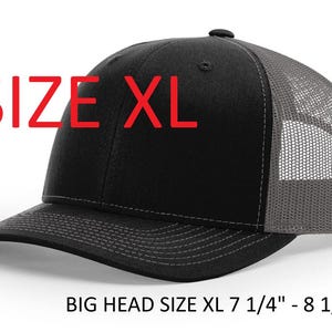 May include: Black and gray XL trucker hat with a mesh back and a curved brim. The hat has the text "SIZE XL" in red. The hat is designed for big heads, fitting sizes 7 1/4" - 8 1/8".
