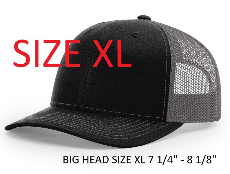 May include: Black and gray XL trucker hat with a mesh back and a curved brim. The hat has the text "SIZE XL" in red. The hat is designed for big heads, fitting sizes 7 1/4" - 8 1/8".