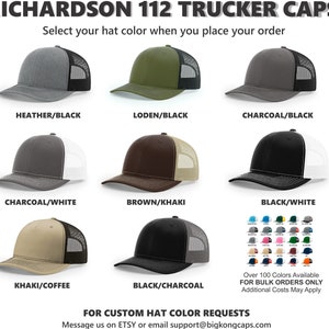 May include: A selection of Richardson 112 trucker caps in various color combinations, including heather/black, loden/black, and charcoal/black. The hats feature a mesh back and a curved brim. The image also displays a color chart with over 100 colors available.