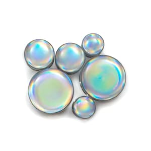 May include: Set of six iridescent ear gauges in various sizes. The gauges are round and have a smooth, shiny finish.
