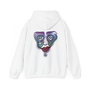 Puede incluir: Sudadera con capucha blanca con una impresión de cara abstracta colorida en la espalda.