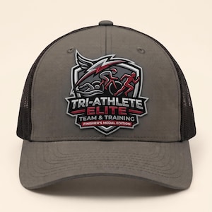 Peut inclure: Une casquette de baseball gris anthracite avec des panneaux latéraux en maille noire. L'avant présente un emblème en forme de bouclier avec un graphique de nageur, cycliste et coureur. Le texte indique : TRI-ATHLETE ELITE TEAM & TRAINING FINISHER'S MEDAL EDITION.