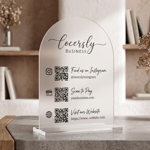 Peut inclure: Un panneau en acrylique dépoli en forme d'arche portant le texte "Locersly BUSINESS". Il présente trois codes QR avec des icônes et du texte : "Find us on Instagram @locerslyinstagram", "Scan to Pay yourbusiness.com" et "Visit our Website https://www.website.com".