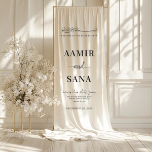 Peut inclure: Un panneau de mariage cr&egrave;me avec un cadre dor&eacute;. Le panneau affiche les noms "AAMIR et SANA" en &eacute;criture noire, ainsi que du texte arabe et la date "DECEMBRE 20, 2025". Un arrangement floral est &agrave; gauche.
